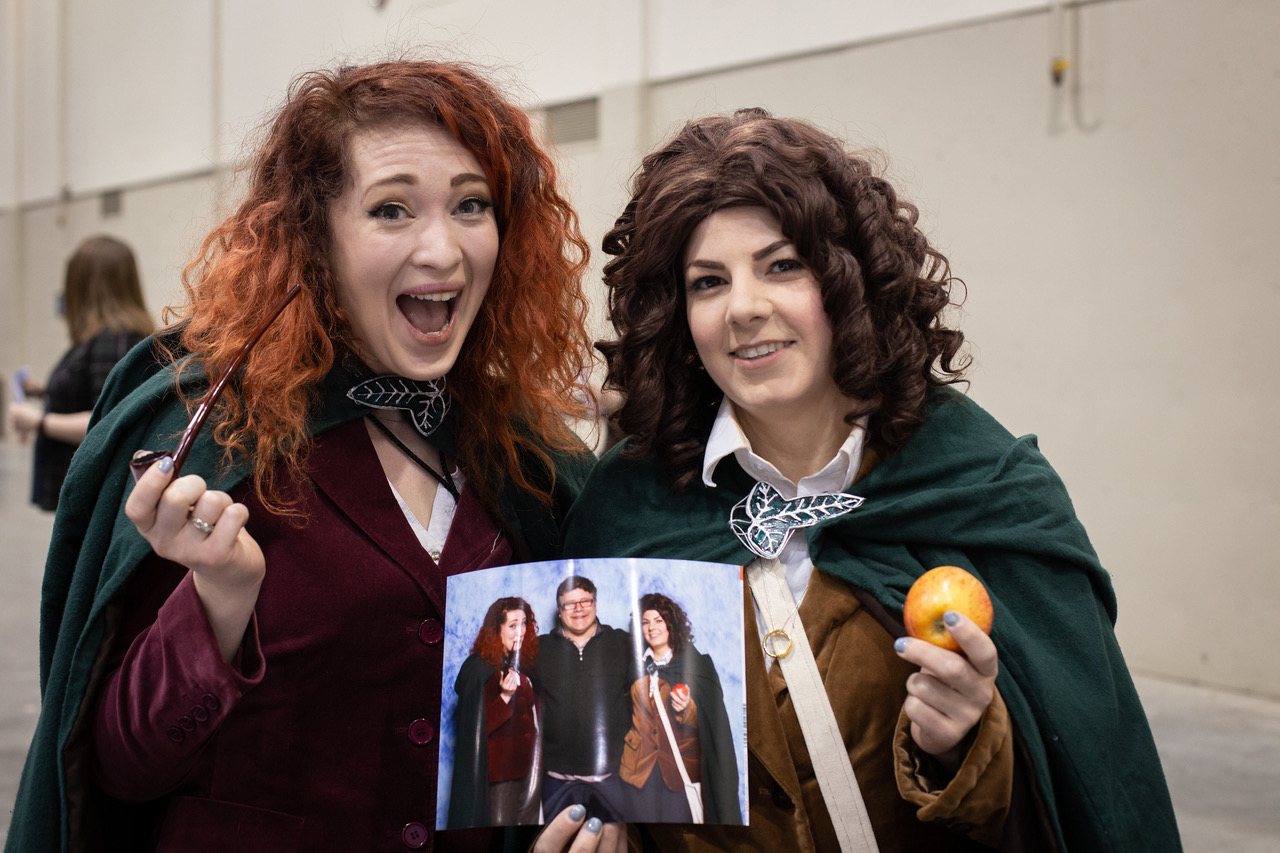 Two people holding a cosplayer photo op image at the Calgary Expo
